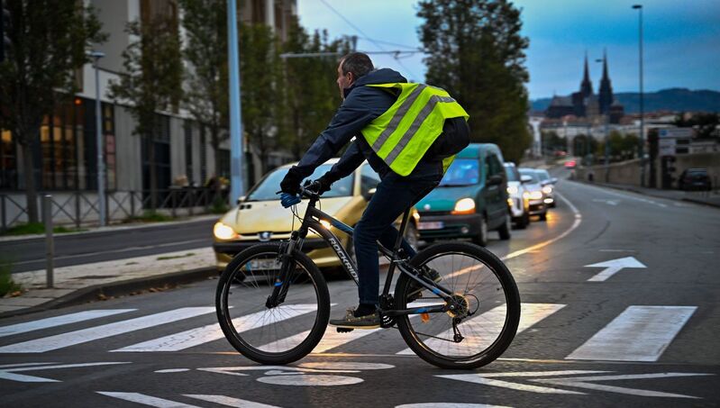 Un homme à vélo porte une veste réfléchissante